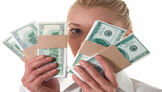 A young woman holds a wad of cash. 