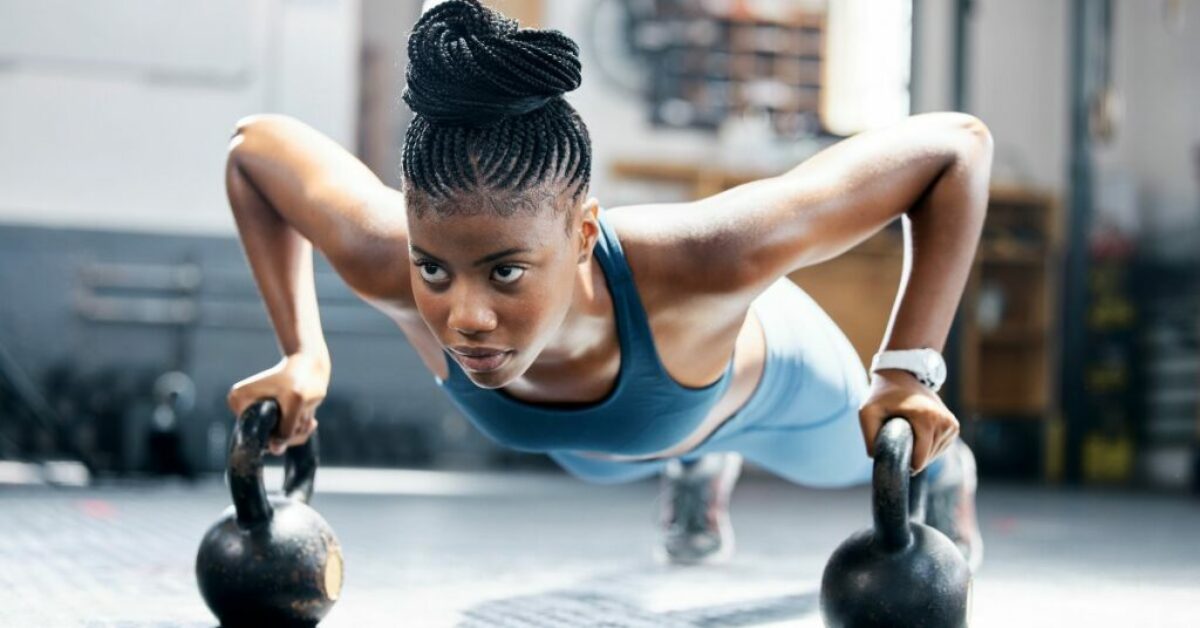 A black woman works out at the gym, demonstrating physical and mental resilience.