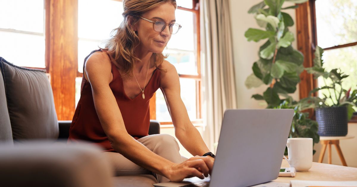 senior woman on laptop indicating a sense of preparation and peace of mind for a secure and enjoyable retirement.