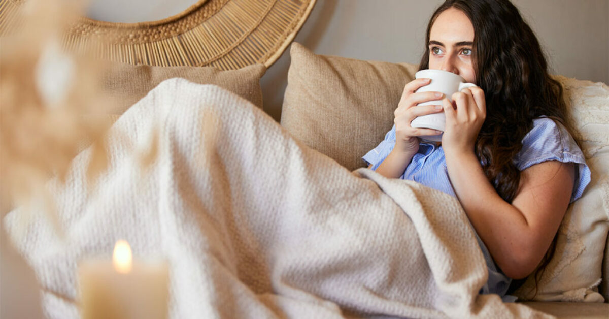 Woman with a coffee thinking about goals and living a fulfilling life.