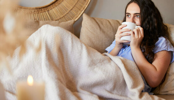 Woman with a coffee thinking about goals and living a fulfilling life.