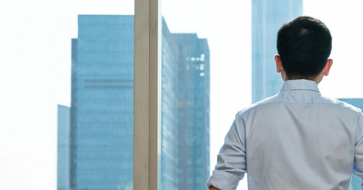 Entrepreneur in front of a window skyscraper, representing success and financial prosperity. 