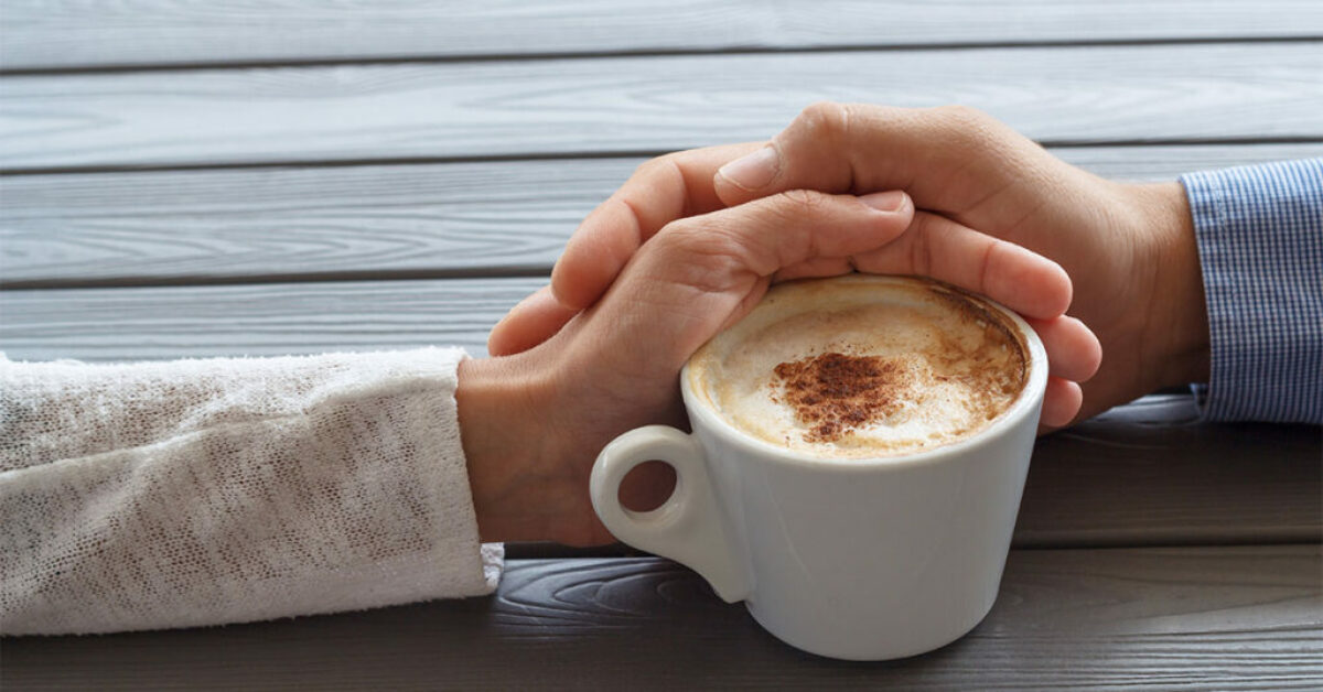 Man and women hold hands with a coffee cup shows how to build trust and strengthen relationship