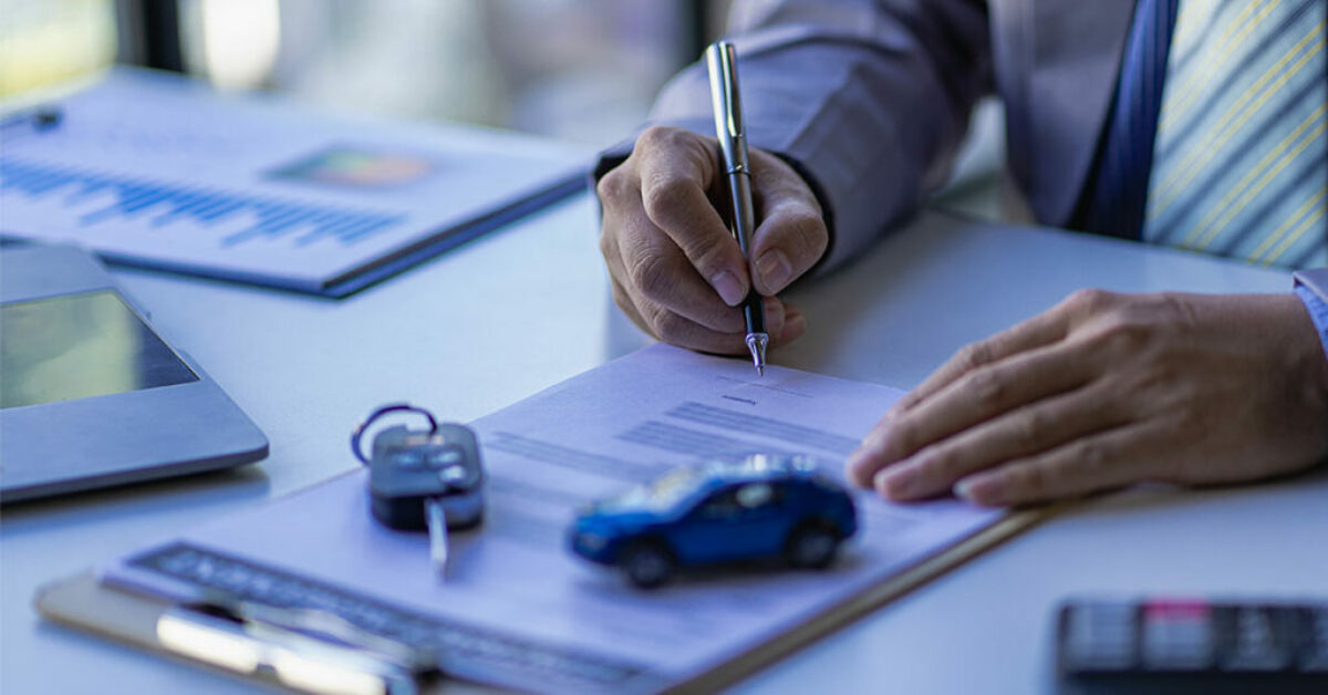 A person is signing insurance papers.
