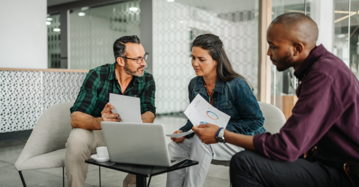 Casual meeting reviewing a successful financial plan on a laptop